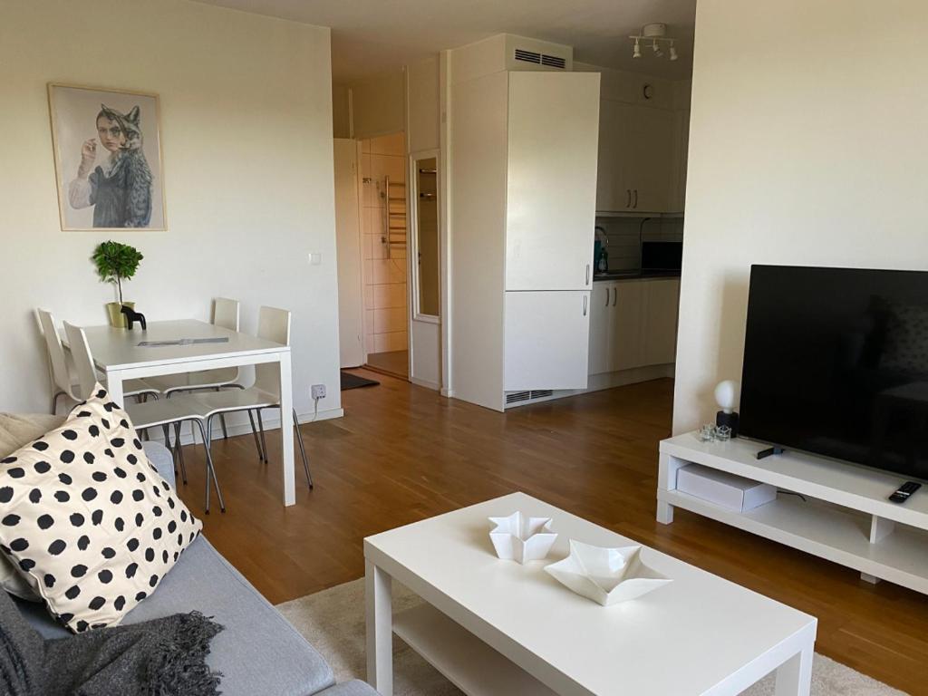 sala de estar con sofá, TV y mesa en Cozy 1 bedroom flat on Lindingo, en Kottla