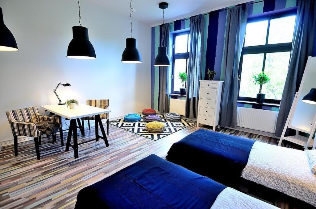 um quarto com uma cama, uma secretária e uma mesa em Victus Apartamenty, Apartament Flamingo em Sopot