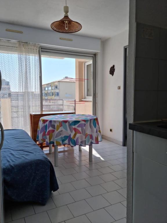 un salon avec une table et une grande fenêtre dans l'établissement T2 sea view in Frontignan Plage, à Frontignan