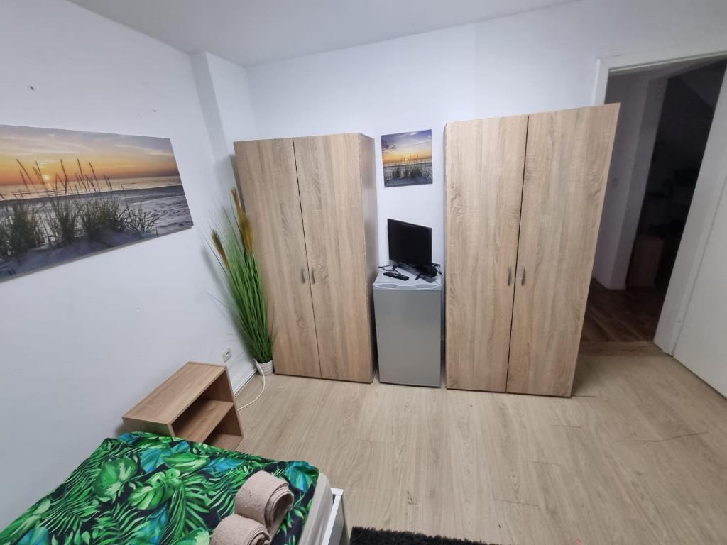 een kamer met houten kasten, een bed en een bureau bij Gästewohnung in der Nähe zum CentrO, DGre in Oberhausen