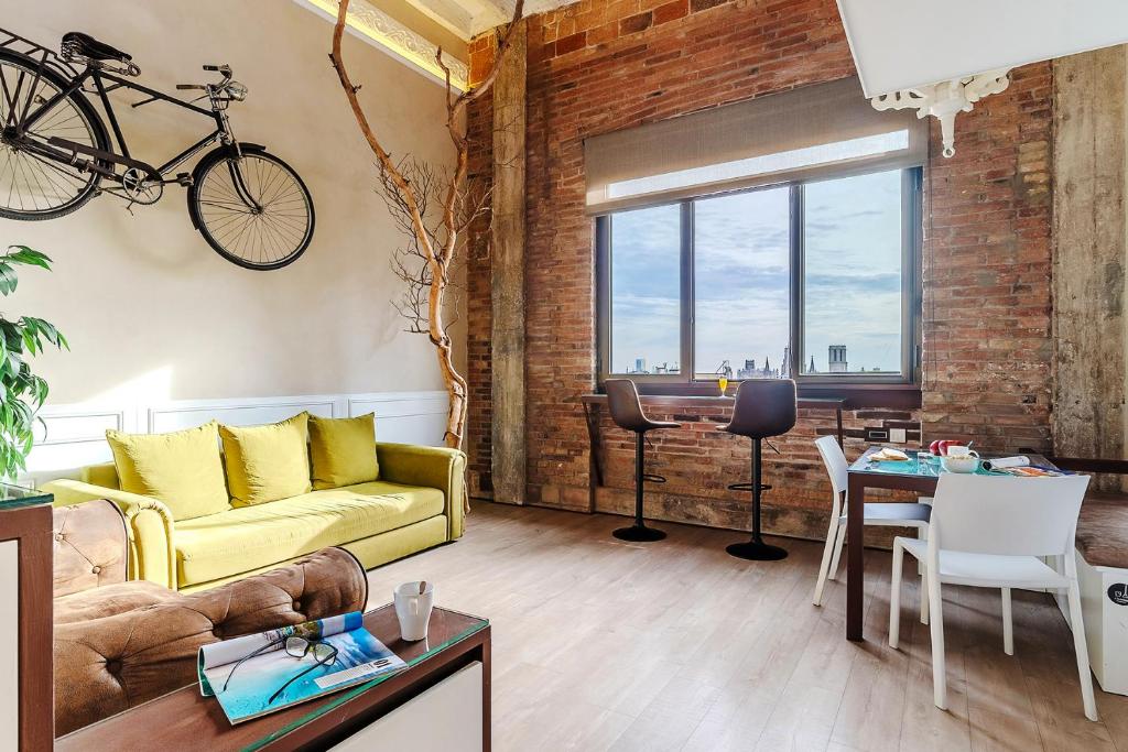 a living room with a yellow couch and a bike hanging on the wall at Enjoybcn Plaza Catalunya Apt. in Barcelona