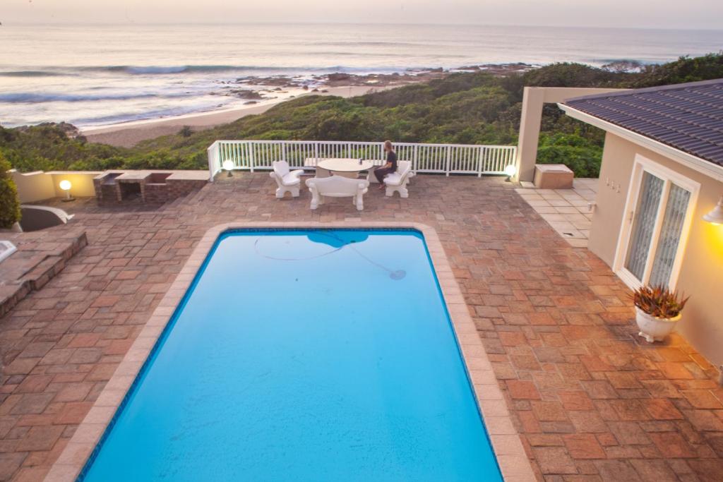 a swimming pool with a view of the beach at Sunrise on Stiebel Rocks in Umzumbe