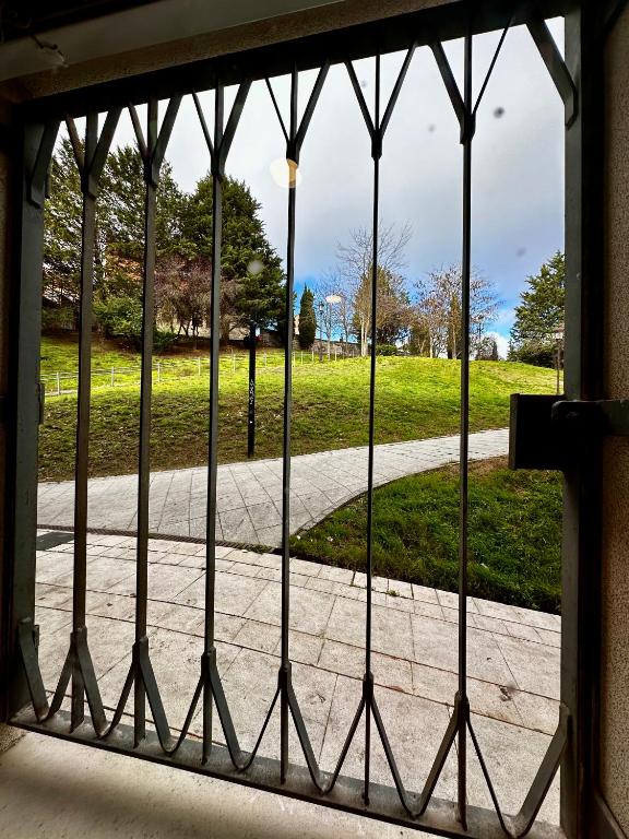 a gate with a view of a park through a window at Los Arcos en el centro histórico de Burgos ATUAIRE in Burgos