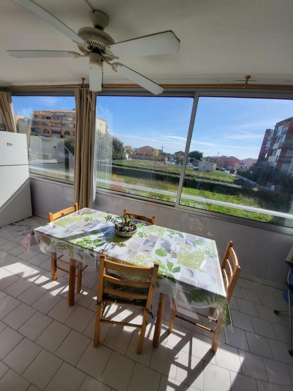 une salle à manger avec une table et des chaises et une fenêtre dans l'établissement Between beach and marina, à Frontignan