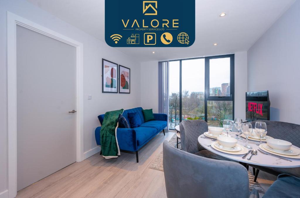 ein Wohnzimmer mit einem Tisch und einem blauen Sofa in der Unterkunft City Cosy 1 bed - Perfect for Long Stays By Valore Property Services in Manchester