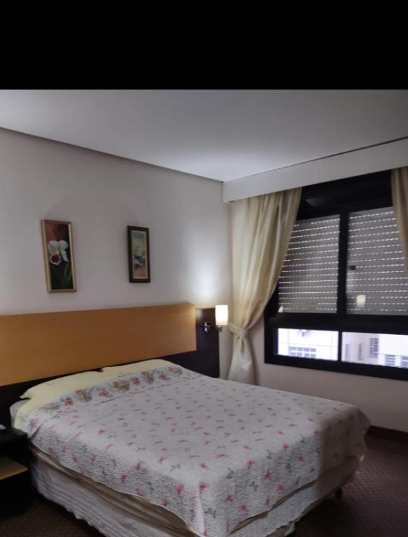 um quarto com uma cama e uma grande janela em Century Park 607 - Apartamento na melhor região da Cidade Baixa em Porto Alegre