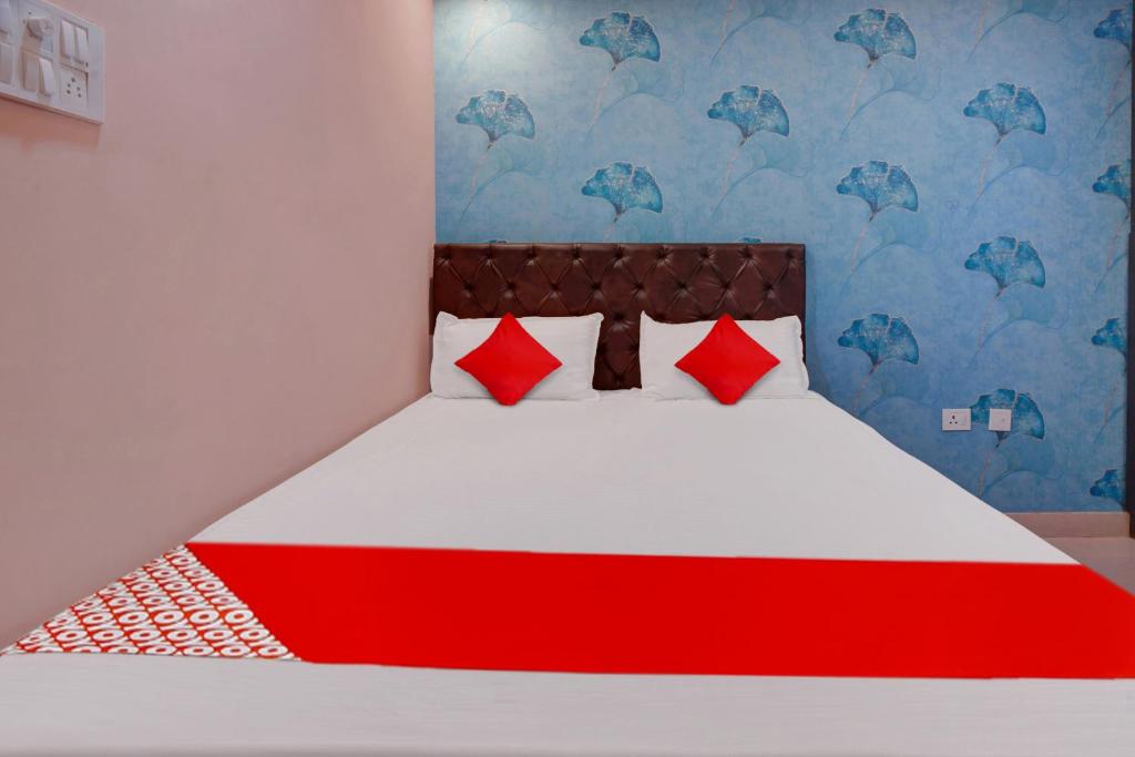 1 cama con almohadas rojas en una habitación en Flagship Hotel Relax Rainbow, en Gulzārbāgh