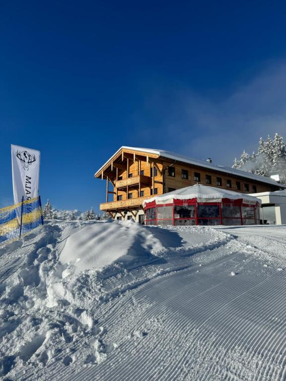 ein Gebäude auf einem schneebedeckten Berg in der Unterkunft GLOCKNERALM in Zell am See