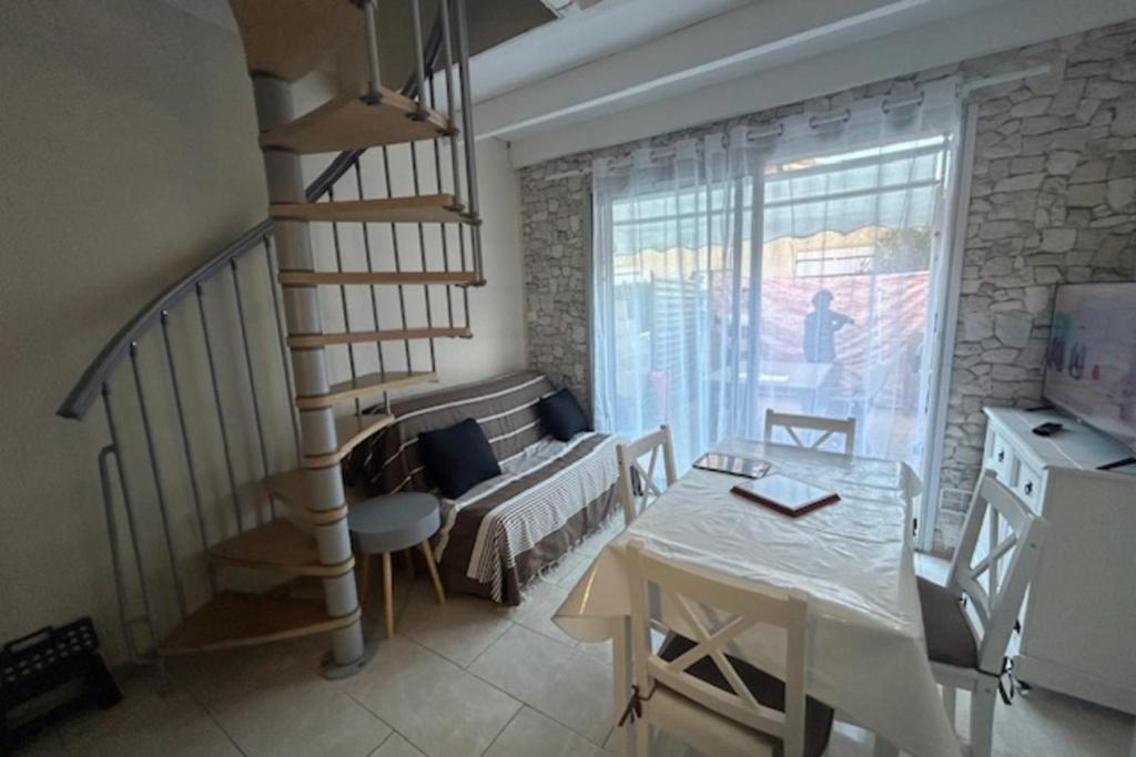 ein Wohnzimmer mit einer Treppe und einem Tisch sowie ein Zimmer mit einem Sofa in der Unterkunft Maisonette by the sea in Frontignan