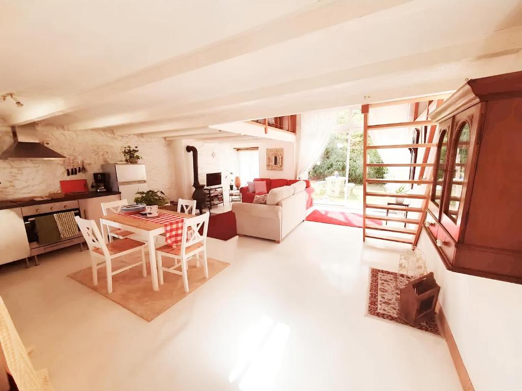 un salon avec une cuisine et une table et des chaises dans l'établissement Gite de Rosaraie, à Beaulieu-sur-Sonnette
