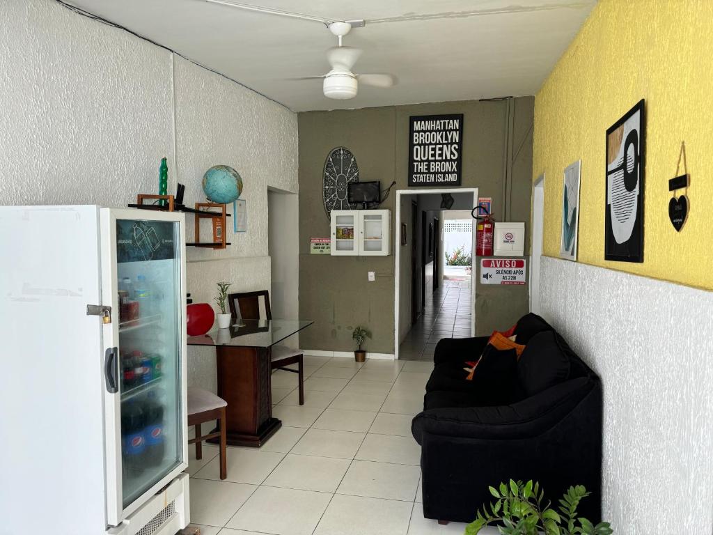 a living room with a couch and a refrigerator at Casa Recife Pousada in Recife