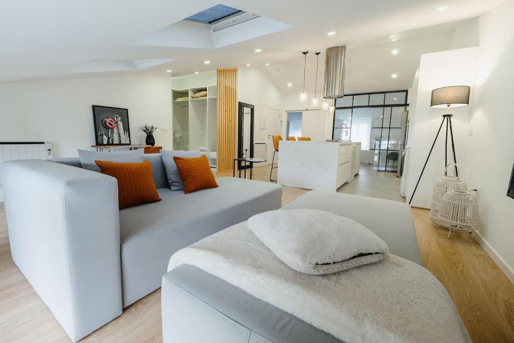 Una sala de estar con un sofá blanco y una mesa. en Ático Isabel, diseño y calidez junto a la Muralla Romana, en Lugo