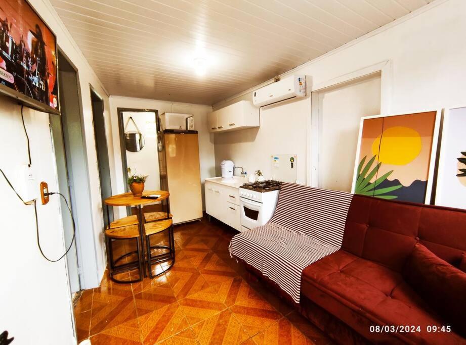 a living room with a couch and a kitchen at Microcasa com vista para o Cristo in Encantado