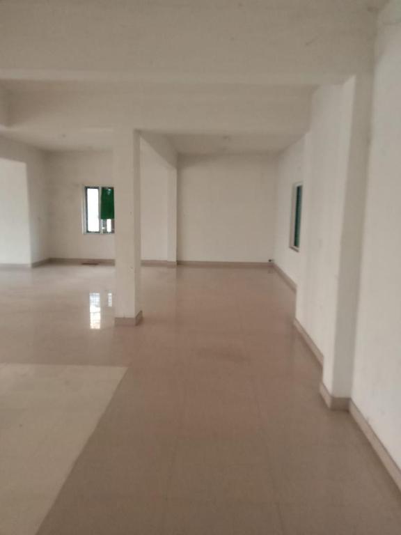 une pièce vide avec des murs blancs et un sol blanc dans l'établissement Kailas 4, à Kollam