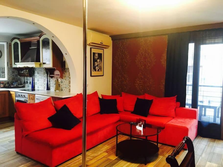 uma sala de estar com um sofá vermelho e uma mesa em Argostoli`s Heard em Argostoli