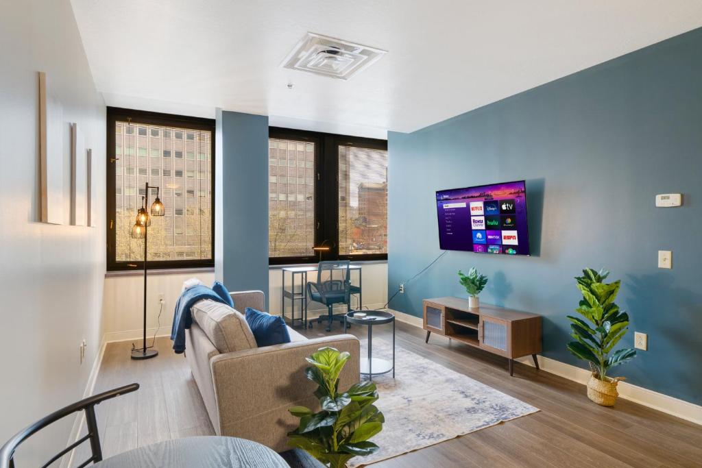 a living room with a couch and a tv on a wall at Vibrant Luxury PRIME LOCATION 24-7 Onsite Parking Gym Lounge in Pittsburgh