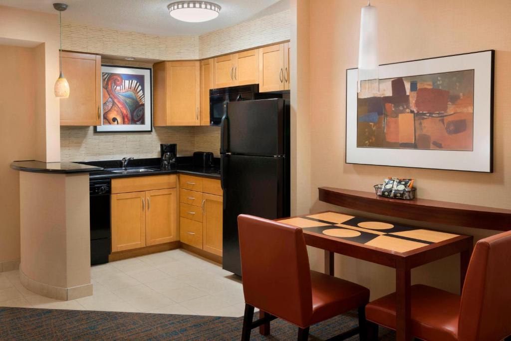 a kitchen with a table and a black refrigerator at Residence Inn by Marriott Toronto Downtown / Entertainment District in Toronto