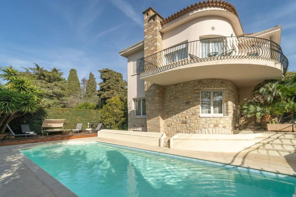 une maison avec une piscine devant une maison dans l'établissement Superbe Nouvelle Villa Moderne, à Cannes