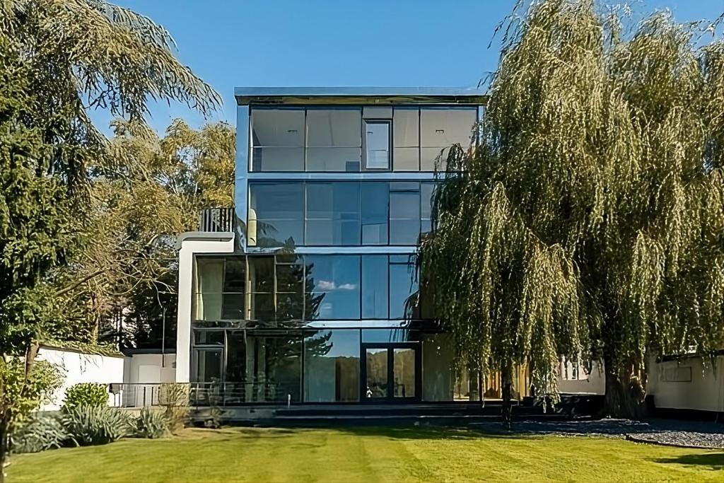 un grande edificio in vetro con un albero di fronte di Villa Rheinblick a Colonia