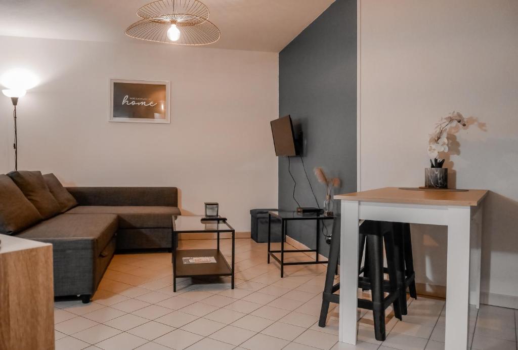 een woonkamer met een bank en een tafel bij St-OrensBnB - Cosi - WIFI - Parking - Terrasse in Saint-Orens-de-Gameville