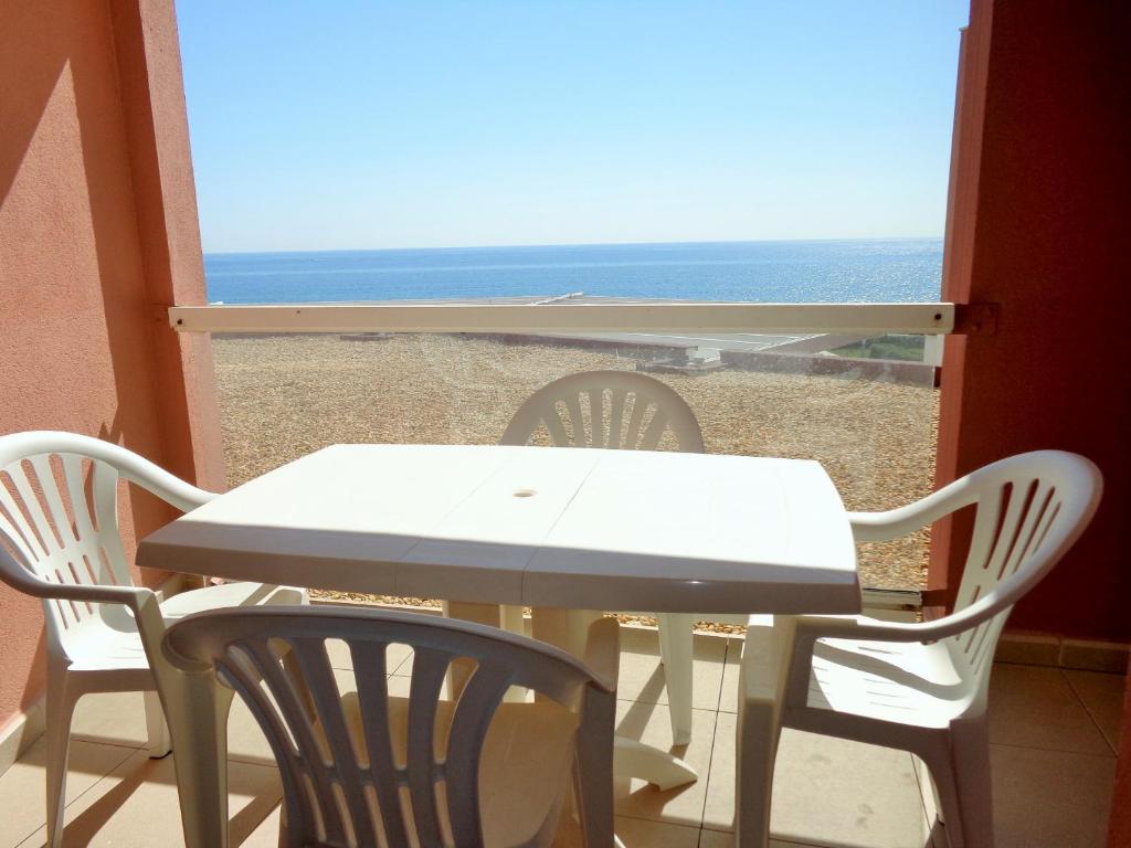 une table et des chaises avec vue sur la plage dans l'établissement CAP CORNICHE studio avec espace nuit, à Sète