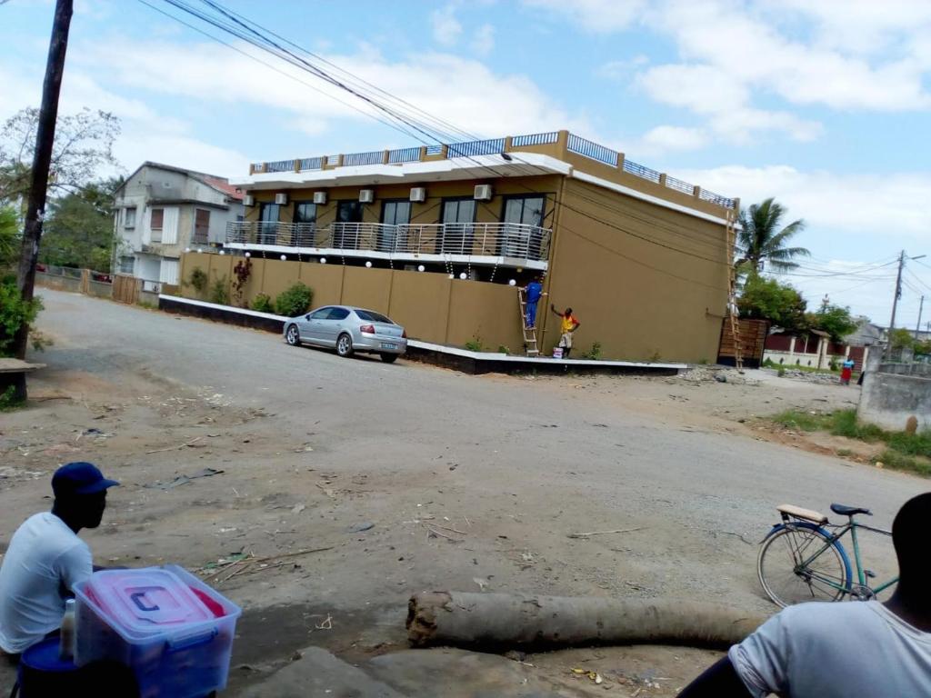 a building on the side of a road with a car at HOTEL COMFORT in Quelimane