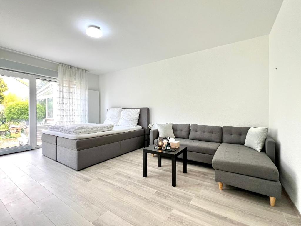 uma sala de estar com um sofá e uma mesa em Comfy Apartment mit Garten in Köln em Colônia