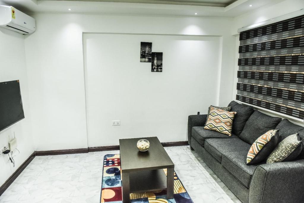 een woonkamer met een bank en een tafel bij Impeccable 1-Bed Airbnb in Borteyman in Kwedonu