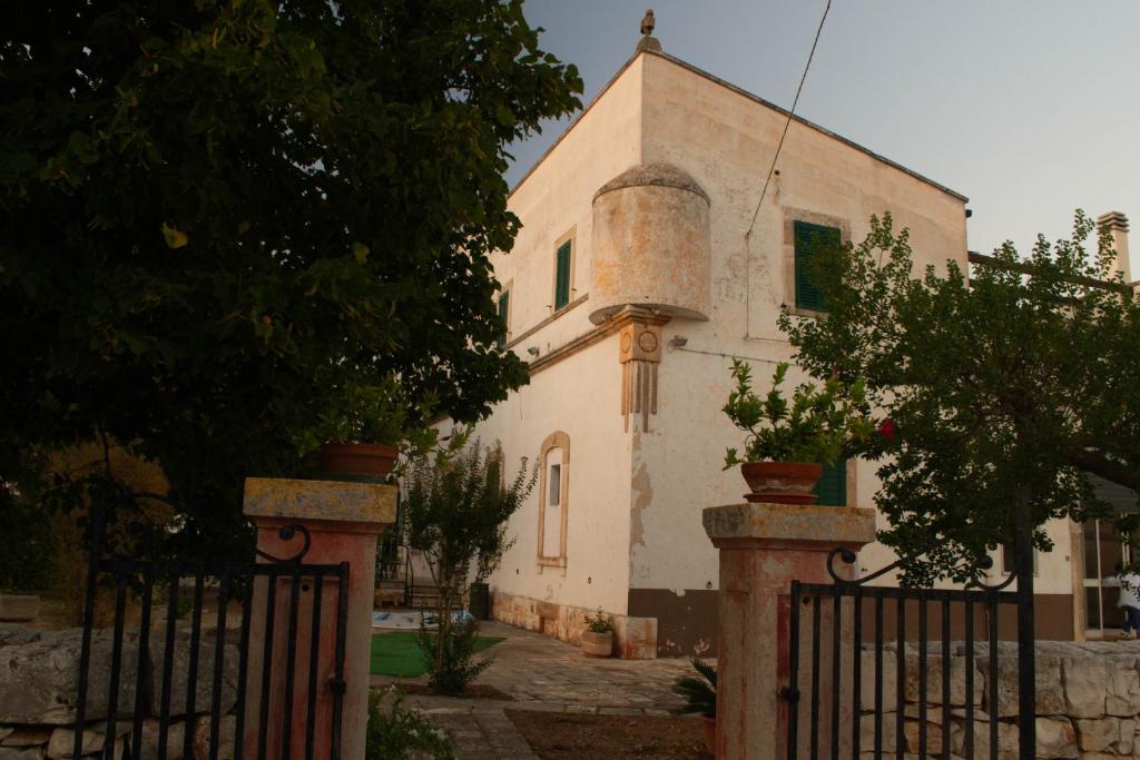 a building with a gate in front of a church at Masseria Olga - Rural Coliving in Turi