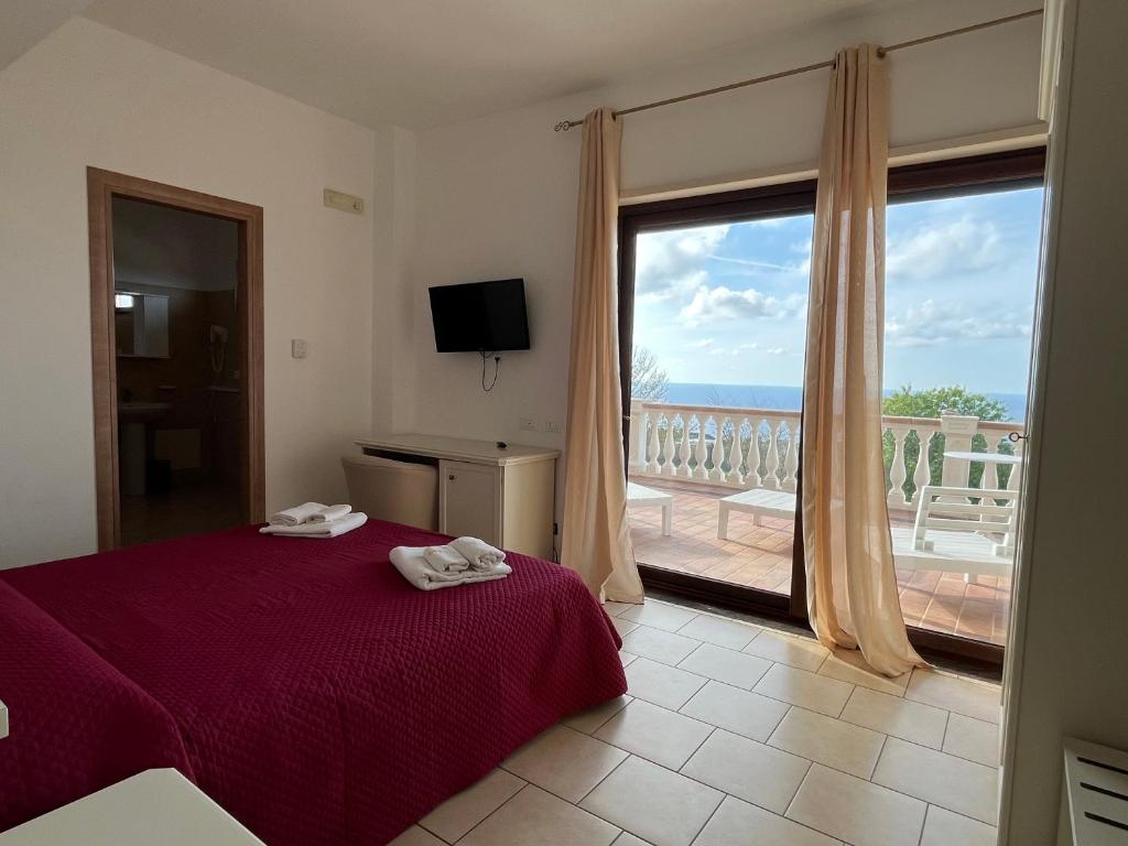 a bedroom with a bed and a view of the ocean at Residenza Domus Aurea Tropea- Vista Mare in Tropea