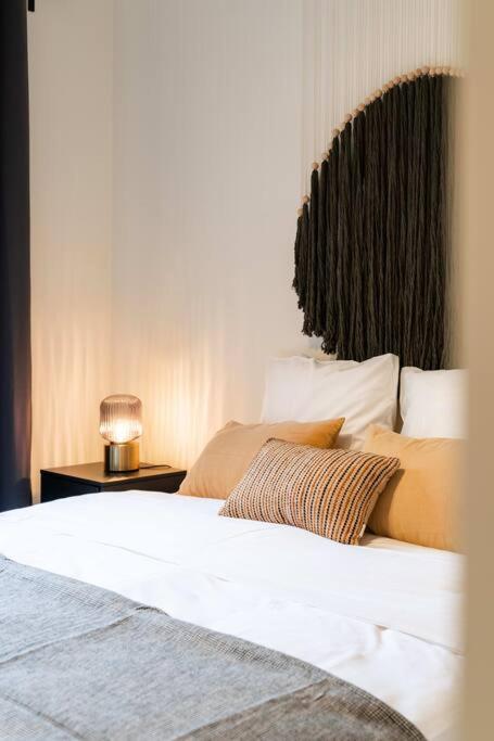 a bedroom with a bed and a night stand with a glass at Beautiful 1BR apartment in Antwerp in Antwerp
