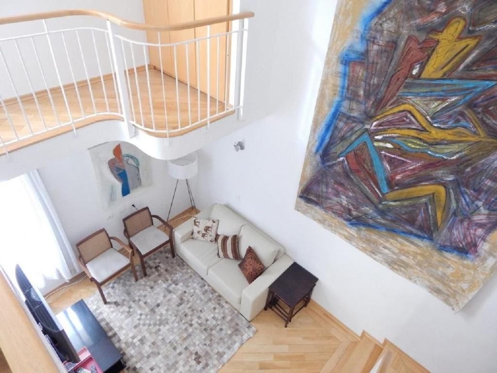 una vista aérea de una sala de estar con una pintura en Jardins House, en São Paulo