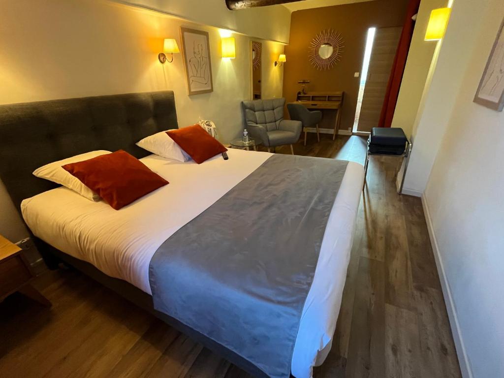 a bedroom with a large bed in a room at Le Clos d'Orange, Hotel & ville de Provence in Orange