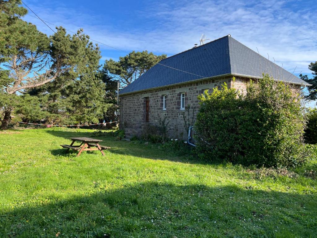 a stone barn with a picnic table in front of it at 361 - Maison 8 couchages située entre le Cap Fréhel et les Sables d'or et face à la Plage de la Anse Du Croc in Fréhel