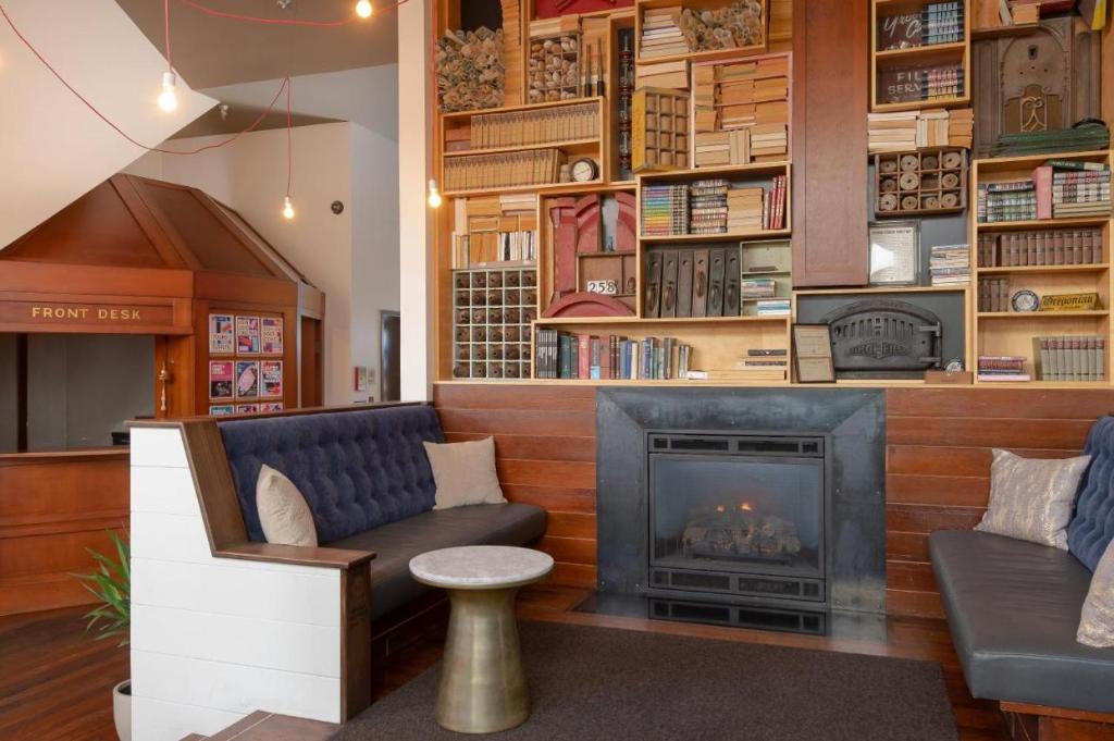 a living room with a fireplace and a book shelf at Commodore Hotel in Astoria, Oregon