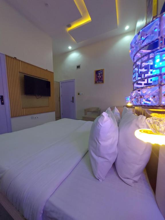 a bedroom with a large bed with white sheets and pillows at Soulmate Hotels & Suites in Lagos