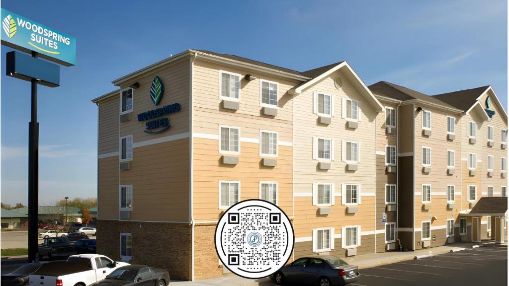 un gran edificio con un cartel delante en WoodSpring Suites Lincoln Northeast I-80 en Lincoln