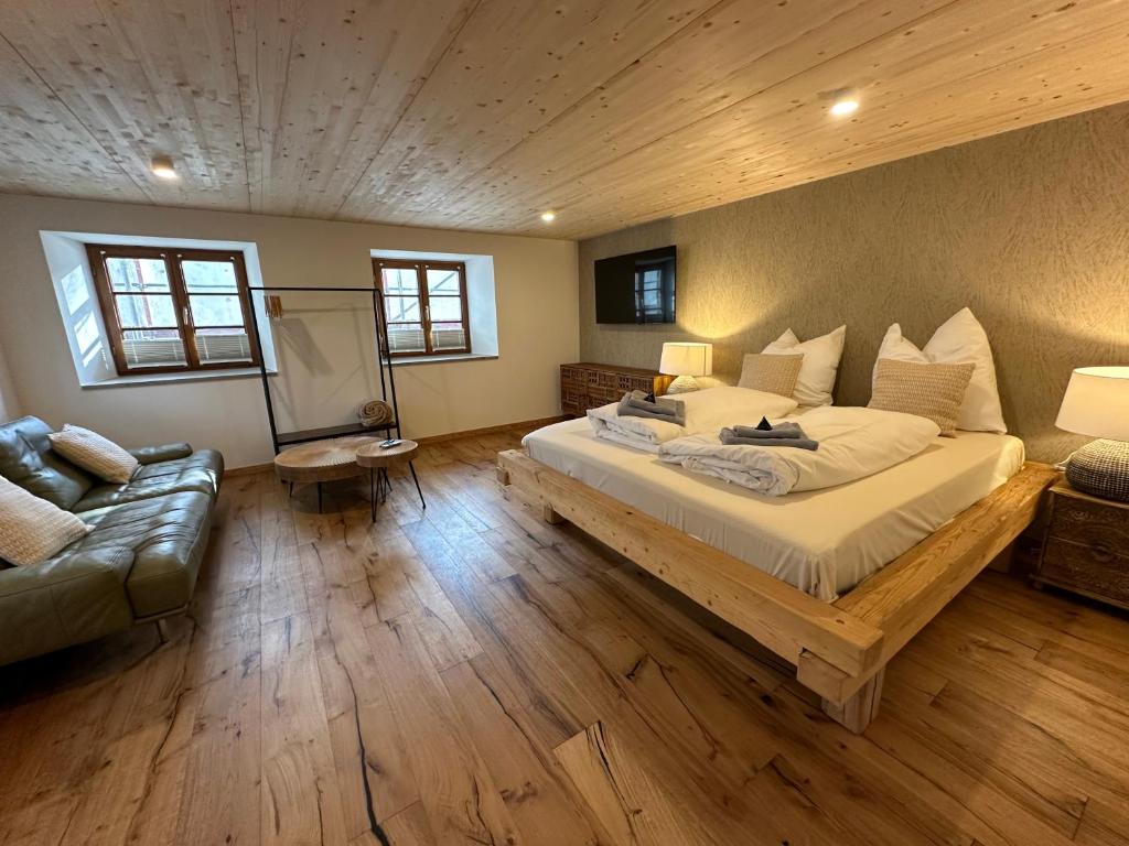 a bedroom with a large bed and a couch at Landhaus am Weissensee in Füssen