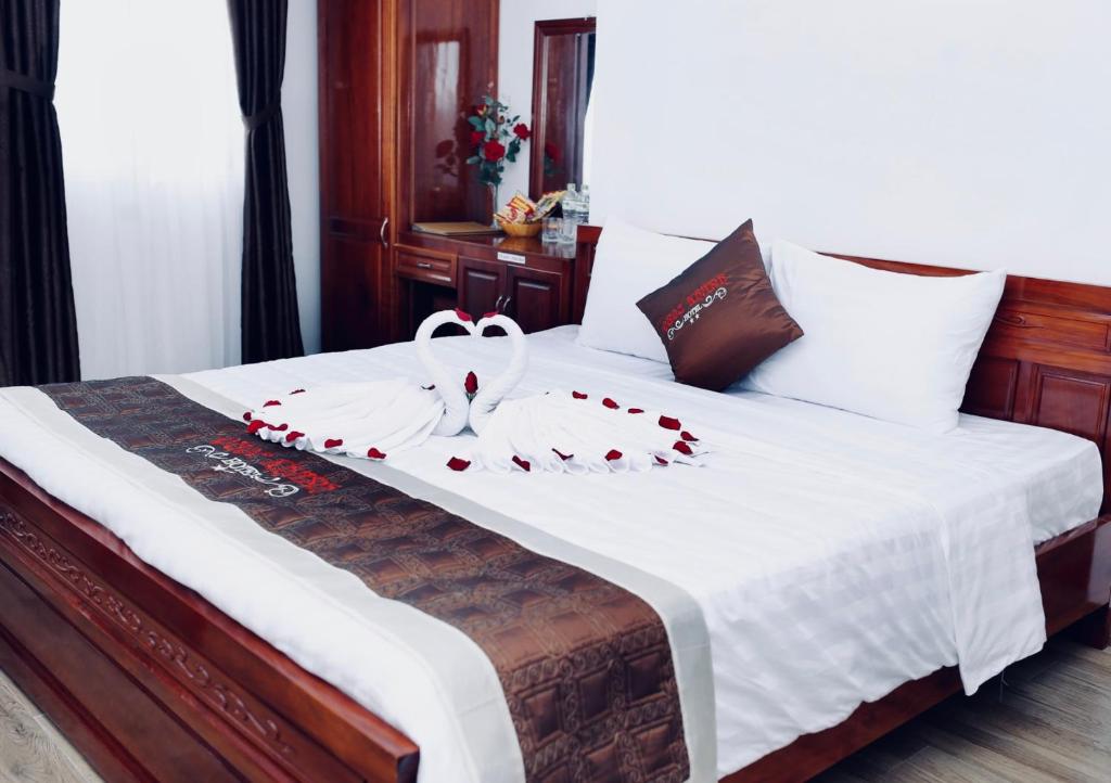 a bedroom with a bed with red roses on it at Quốc Khánh Hotel Da Nang in Da Nang