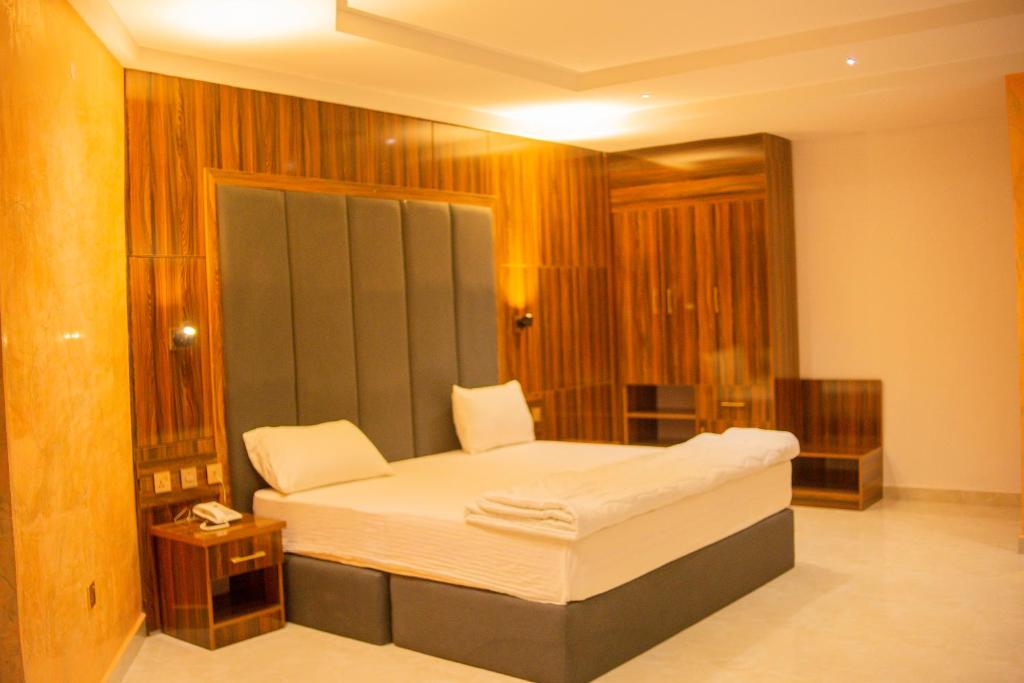 a bedroom with a large bed in a room at Jimaco Hotels and Suites in Uyo