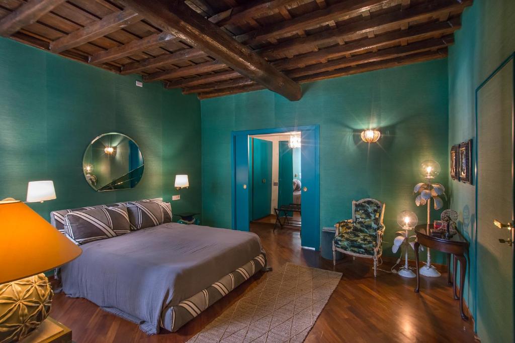 ein Schlafzimmer mit grünen Wänden, einem Bett und einem Stuhl in der Unterkunft Ripense in Rom