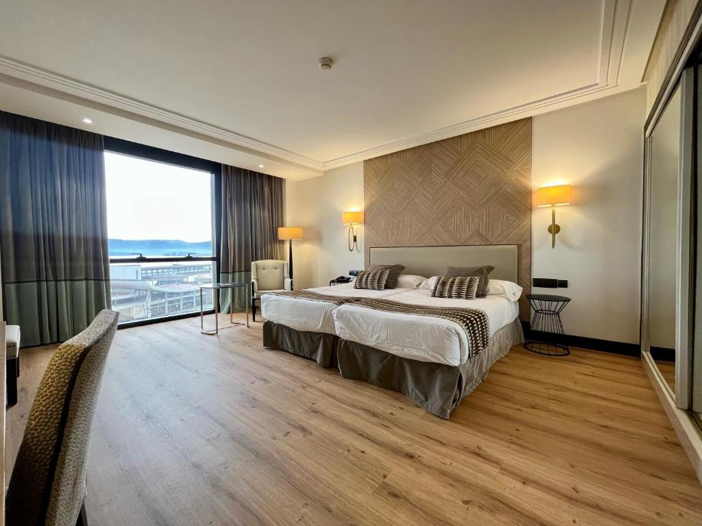a hotel room with a bed and a large window at Hotel Bahía in Santander
