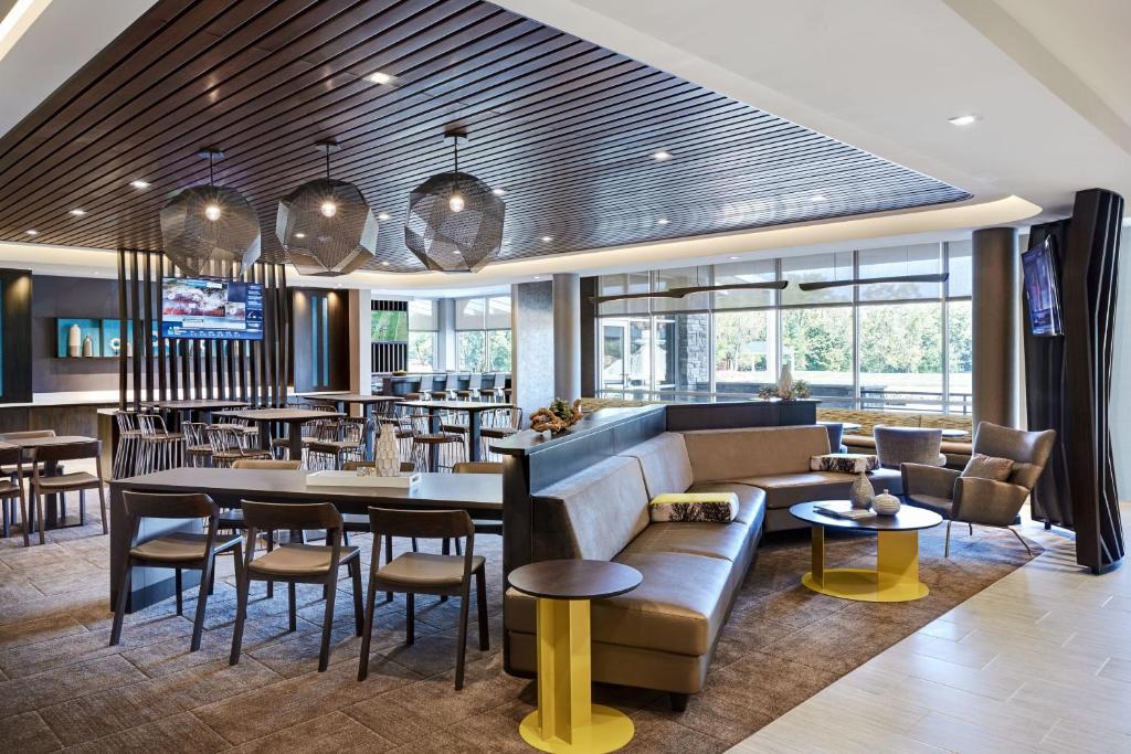 ein Restaurant mit einem Sofa, Tischen und Stühlen in der Unterkunft SpringHill Suites by Marriott Tampa Downtown in Tampa