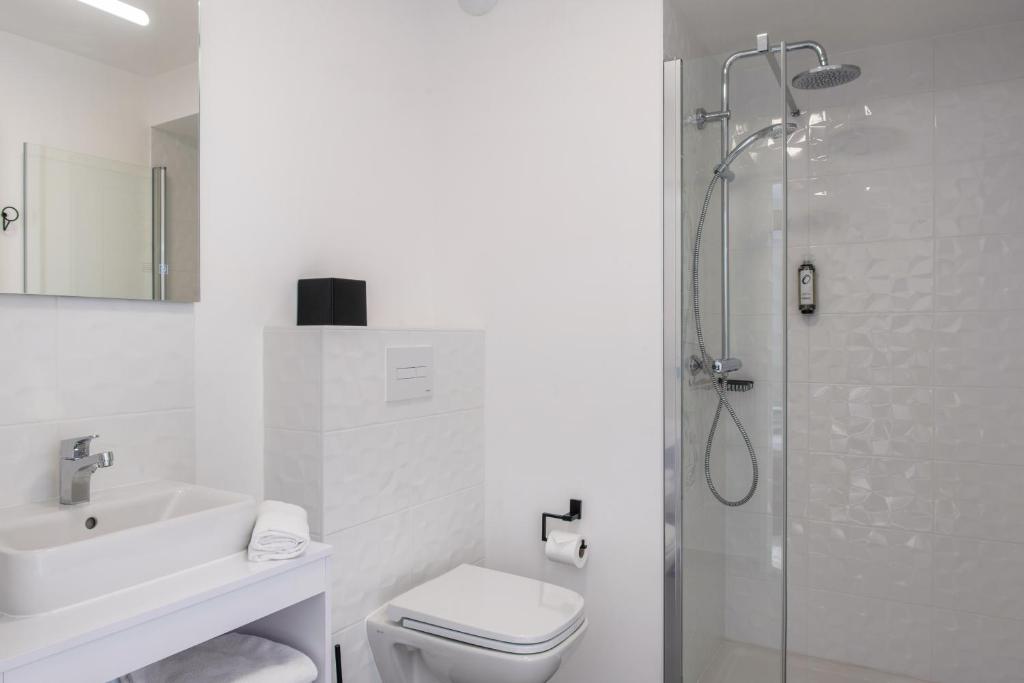 a bathroom with a shower and a toilet and a sink at The Originals Residence, Le Wax, Lille Est in Villeneuve d&#39;Ascq