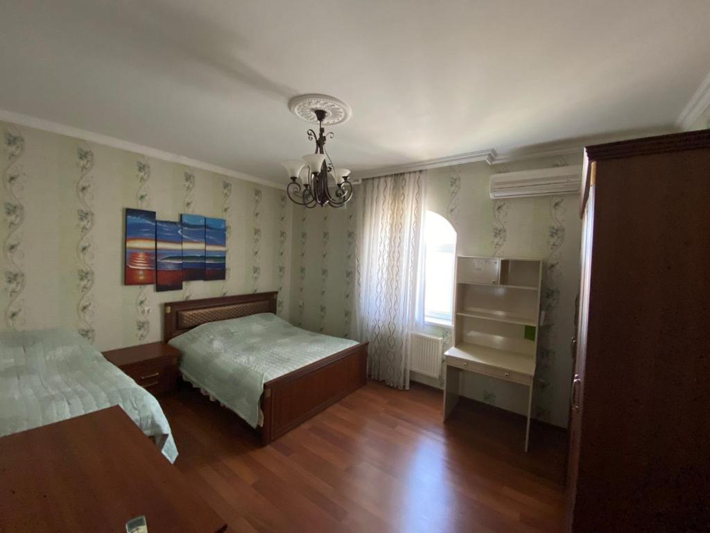 1 dormitorio con 2 camas y lámpara de araña en SHAGAN VILLA, en Buzovna