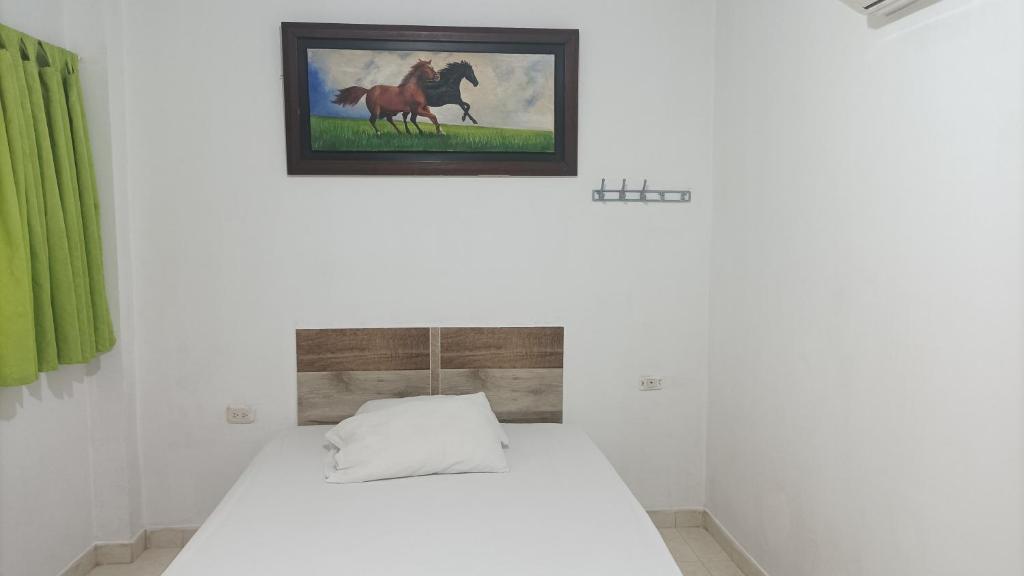 a bed in a room with a picture on the wall at HOTEL LA MATA 