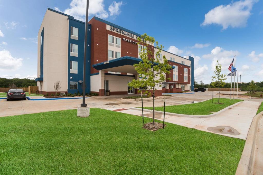 un bâtiment avec une pelouse verte devant lui dans l'établissement SpringHill Suites by Marriott Stillwater, à Stillwater