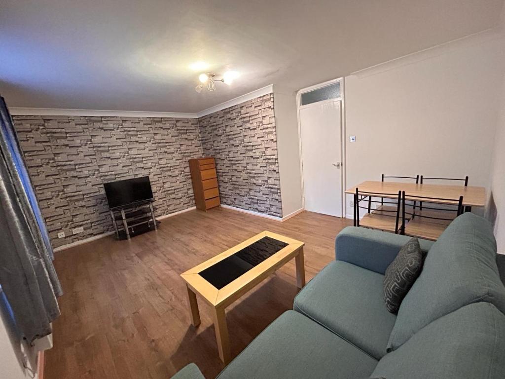 a living room with a couch and a table at Spacious one bed flat in eastlondon with parking and free wifi in Goodmayes