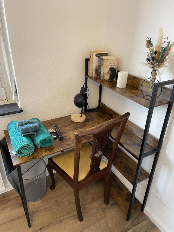 einen Holztisch mit einem Stuhl und einen Schreibtisch mit einem Bücherregal in der Unterkunft 3-Zimmer-Wohnung / 10min vom ICE in Siegburg