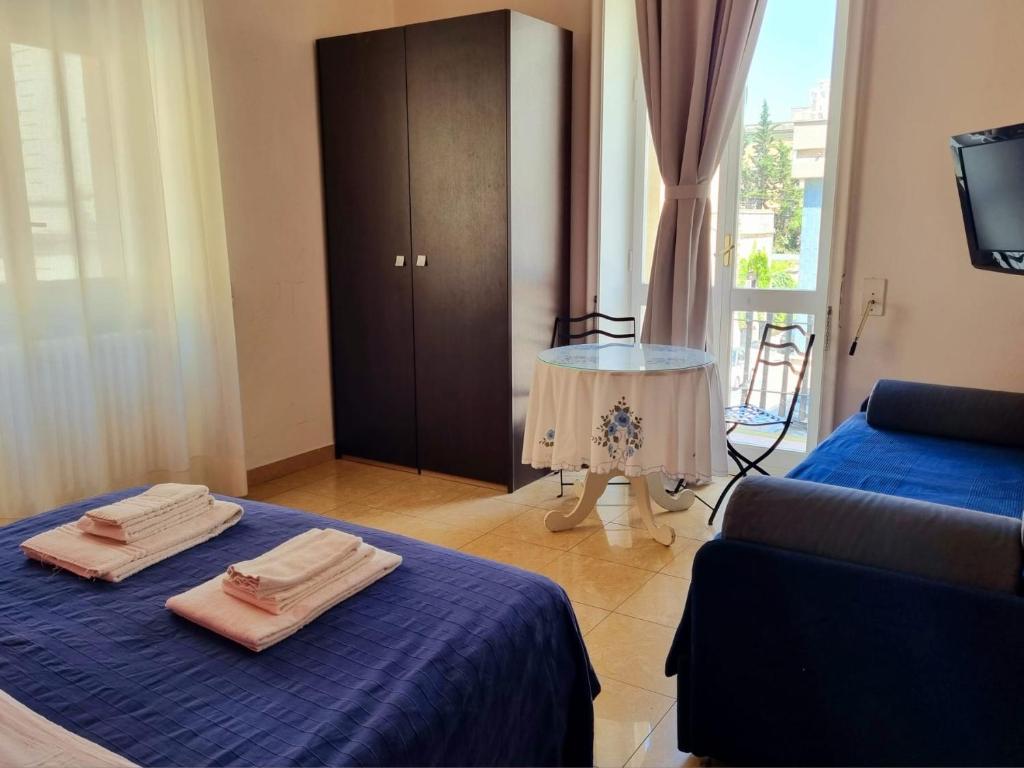 レッチェにあるH Central Lecceのベッド2台、ソファ、テーブルが備わる客室です。